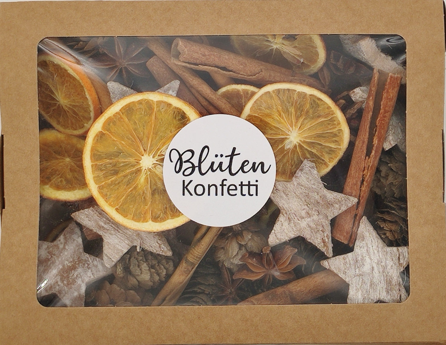 Boîte de Noël avec des tranches d'orange séchées, de l'anis étoilé, des bâtons de cannelle, des cônes de mélèze et des étoiles de noix de coco blanches
