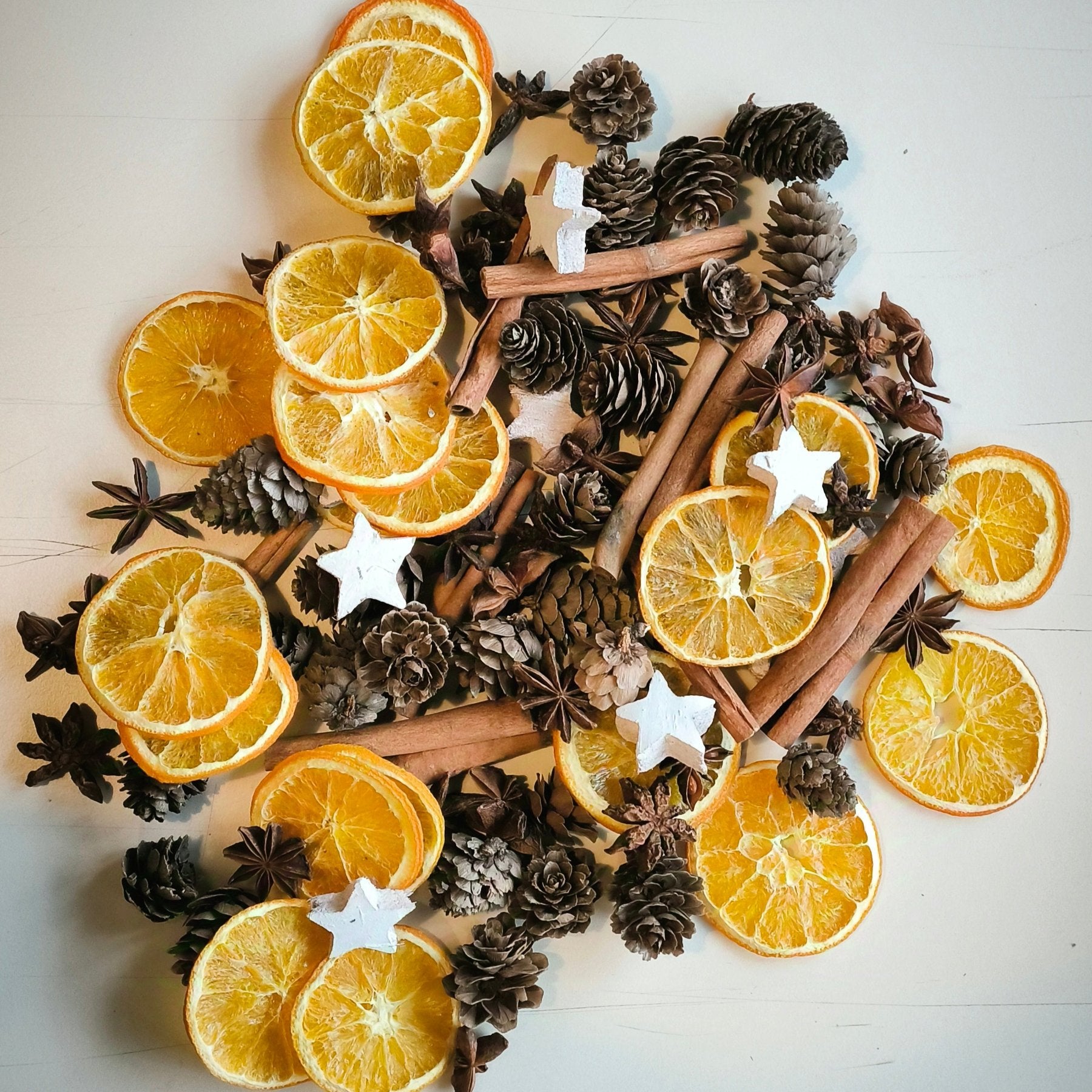 Christmas Box mit getrockneten Orangenscheiben, Sternanis, Zimtstangen, Lärchen-Zapfen und weißen Kokossternen