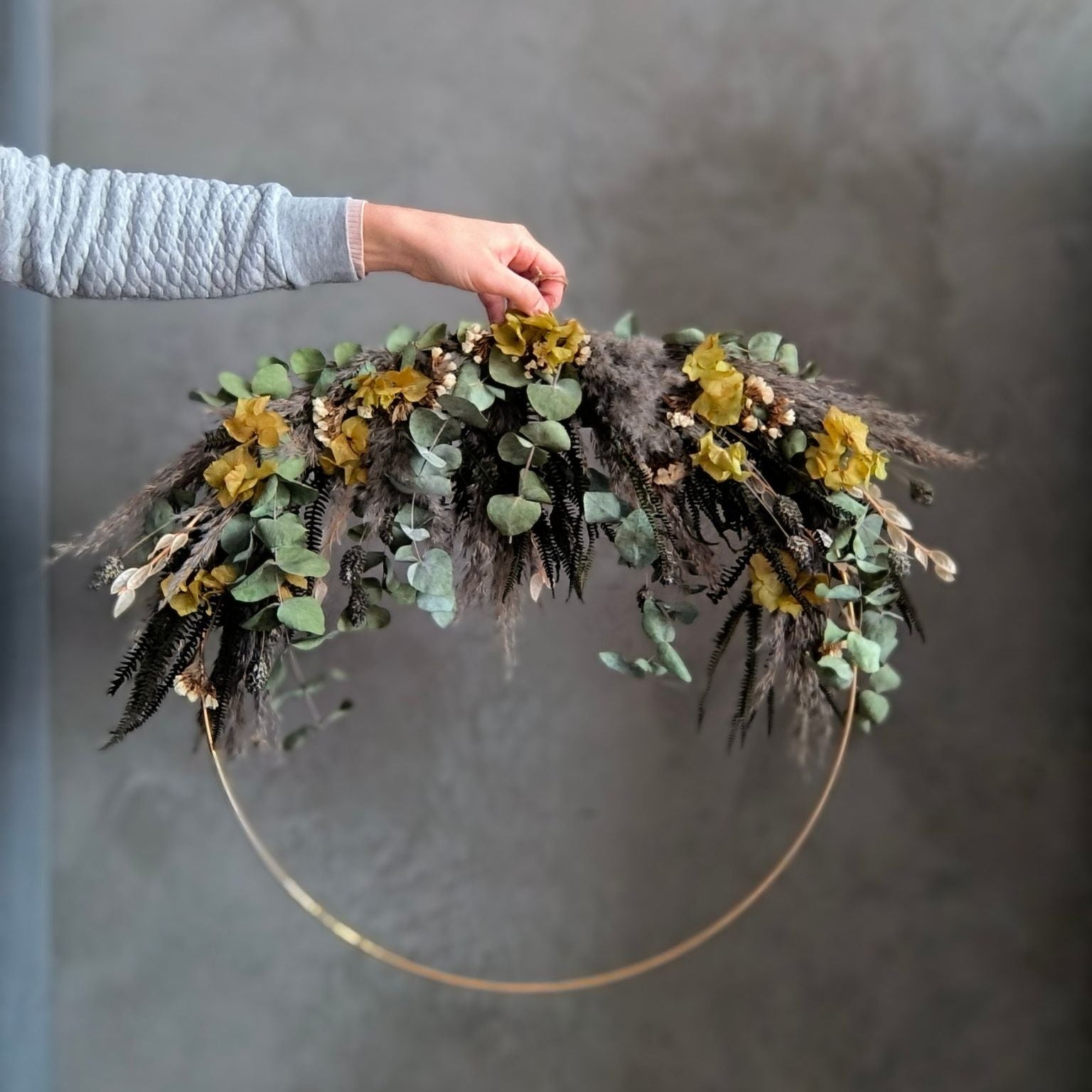 Boho Eukalyptus Großer Trockenblumenring in naürlichen grün und Grautönen in der Hand
