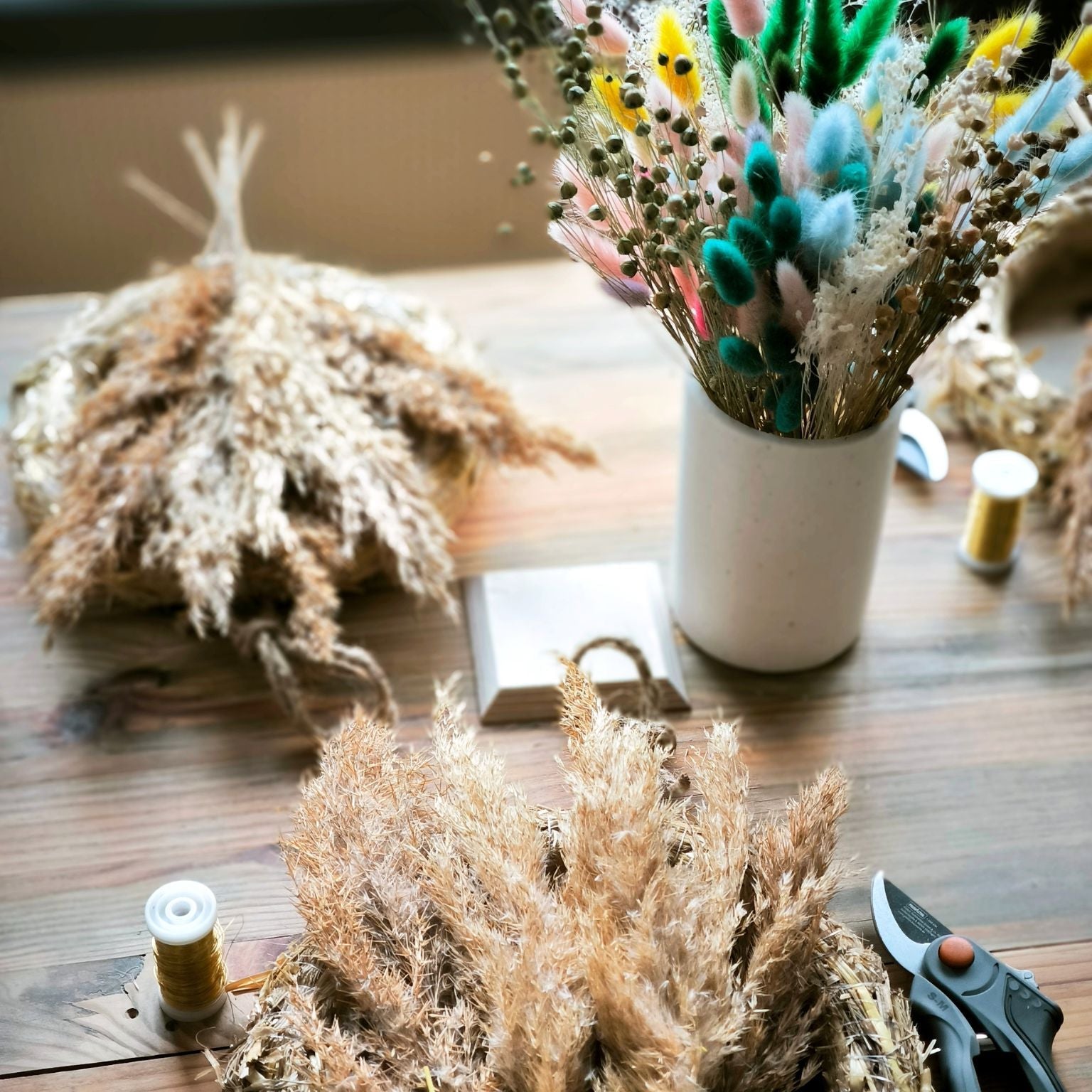 Zeitgeschenk für Gruppen Türkranz aus Trockenblumen gestalten Detailaufnahme Arbeitsbereich mit Kranz